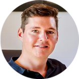 Person mit kurzem braunem Haar in einem Büro oder Arbeitsumfeld